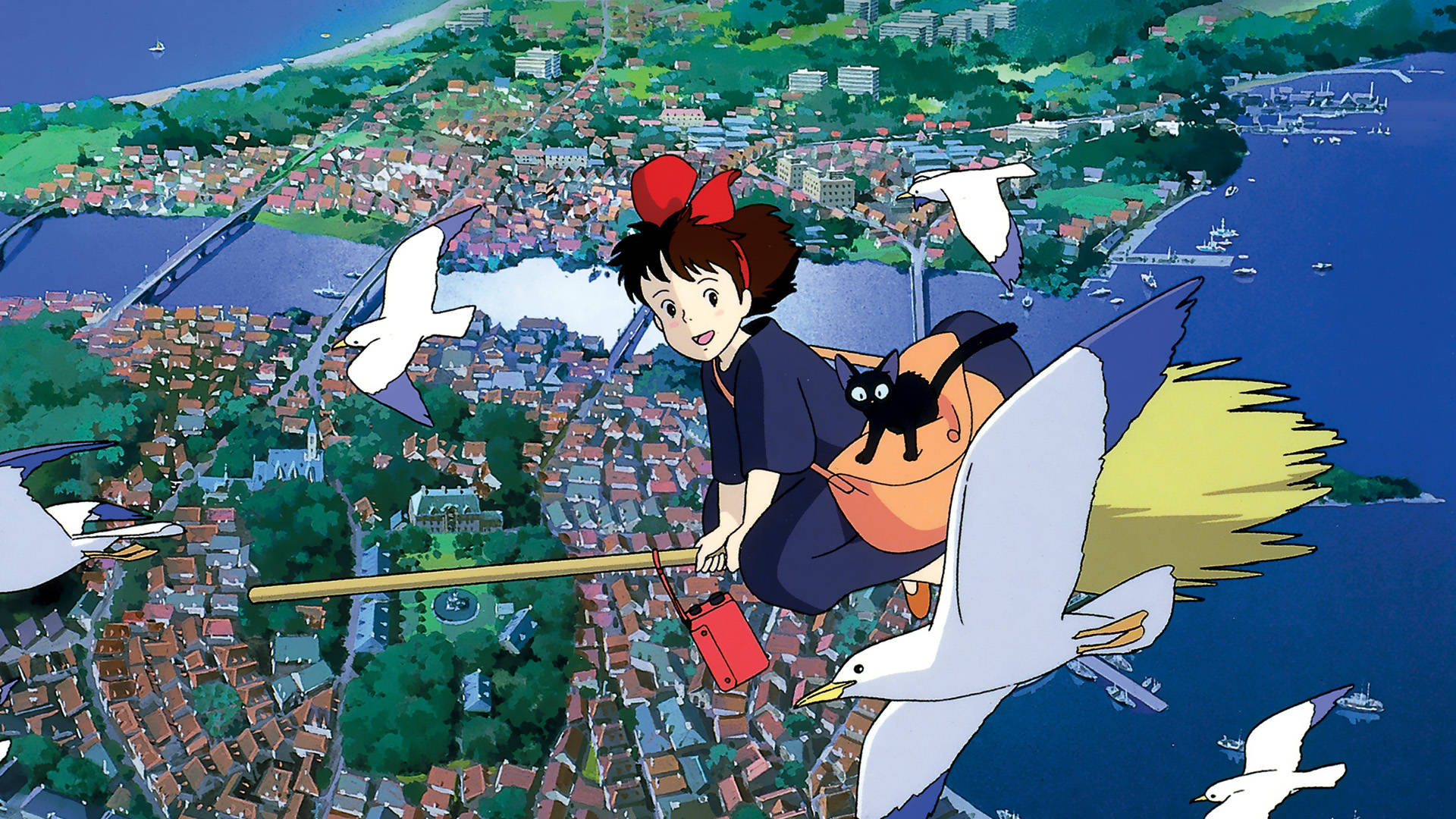 Kiki and her black cat Jiji flying on a broomstick alongside seagulls, high above a scenic seaside town.
